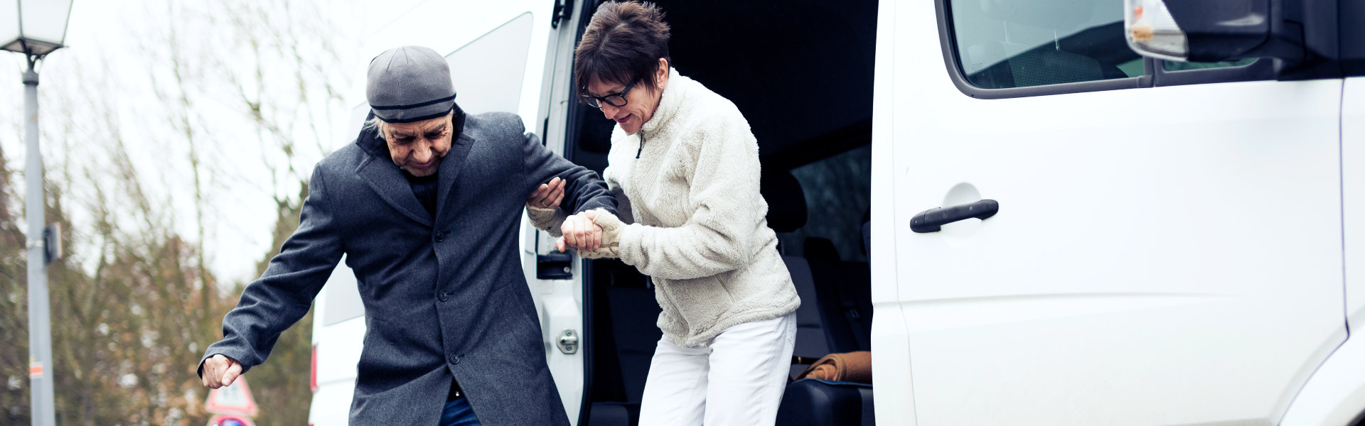 Nurse Helping Senior Man Exit A Van